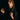 A woman in a dark cloak in low light, moody romantic gothic portrait